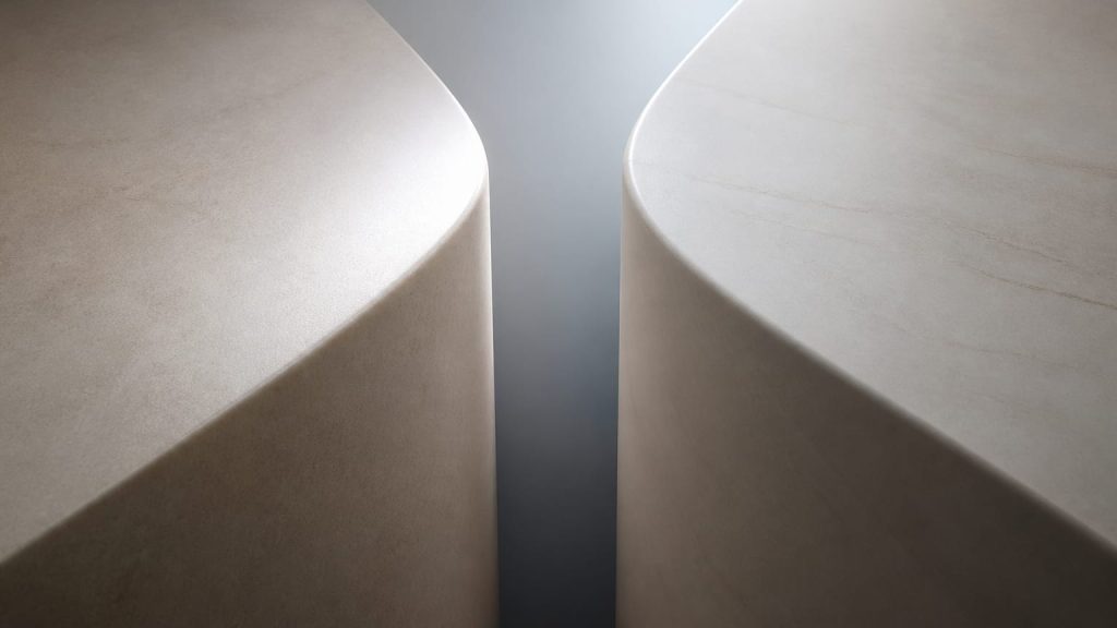 A narrow shadowed gap between two smooth curved surfaces under soft studio light.