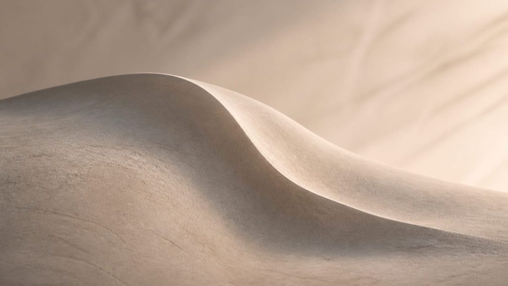 Abstract clay-like surface with one gently fading ridge under soft side lighting.