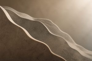 Abstract layered stone forms with a soft curved edge fading into shadow on a muted background